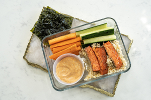 glass lunch container with carrots, cucumbers, rice, fish, & spicy mayo