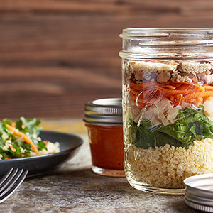 A mason jar on a table is filled with Asian Sesame Mason Jar Salad