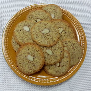 A tan plate holds several Crisp Frangipane Cookies