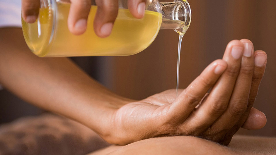 medium toned skin hand getting yellow oil poured into it