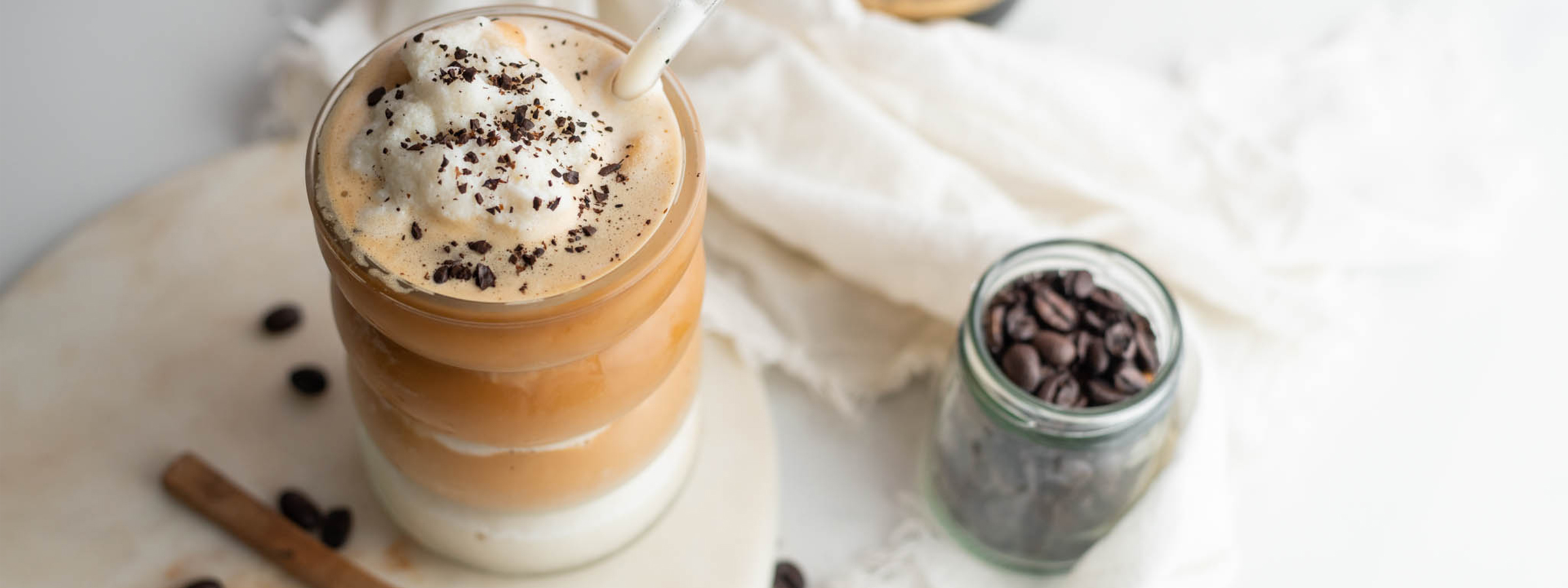 top view of Frozen Amaretto Coffee Latte with a jar of coffee beans next to it