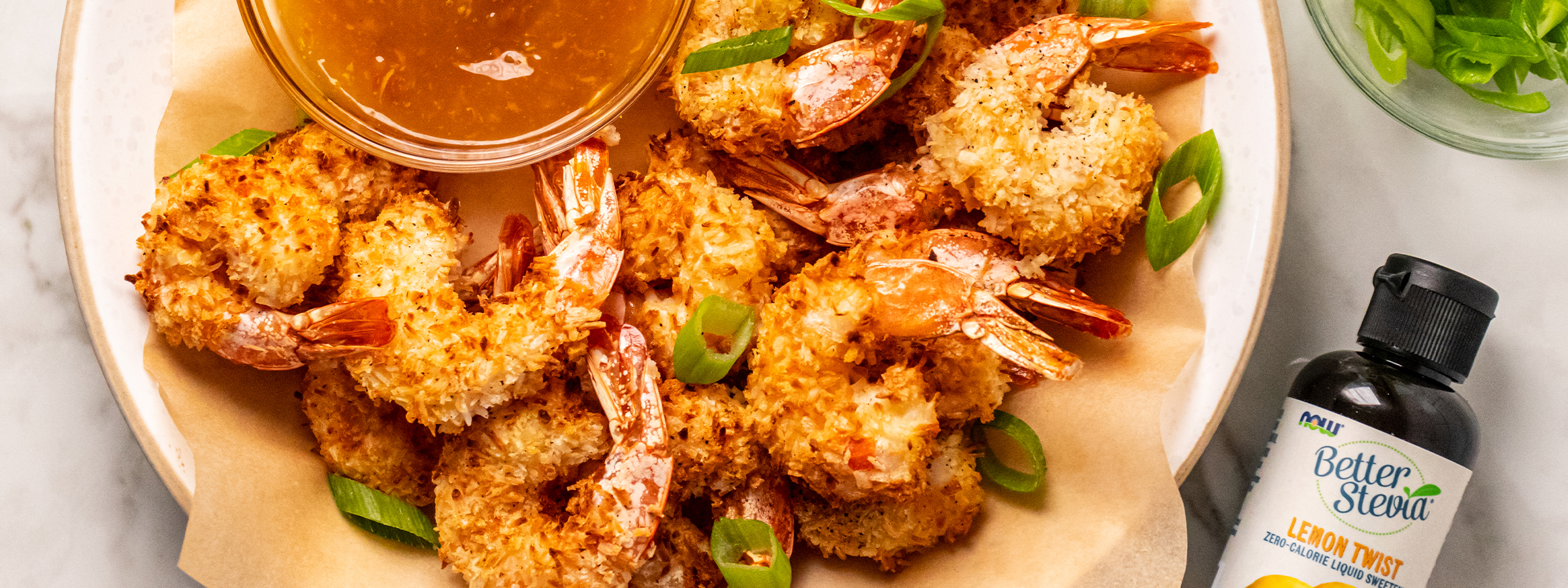 Top view of air fired coconut shrimp with bottle of lemon twist better stevia