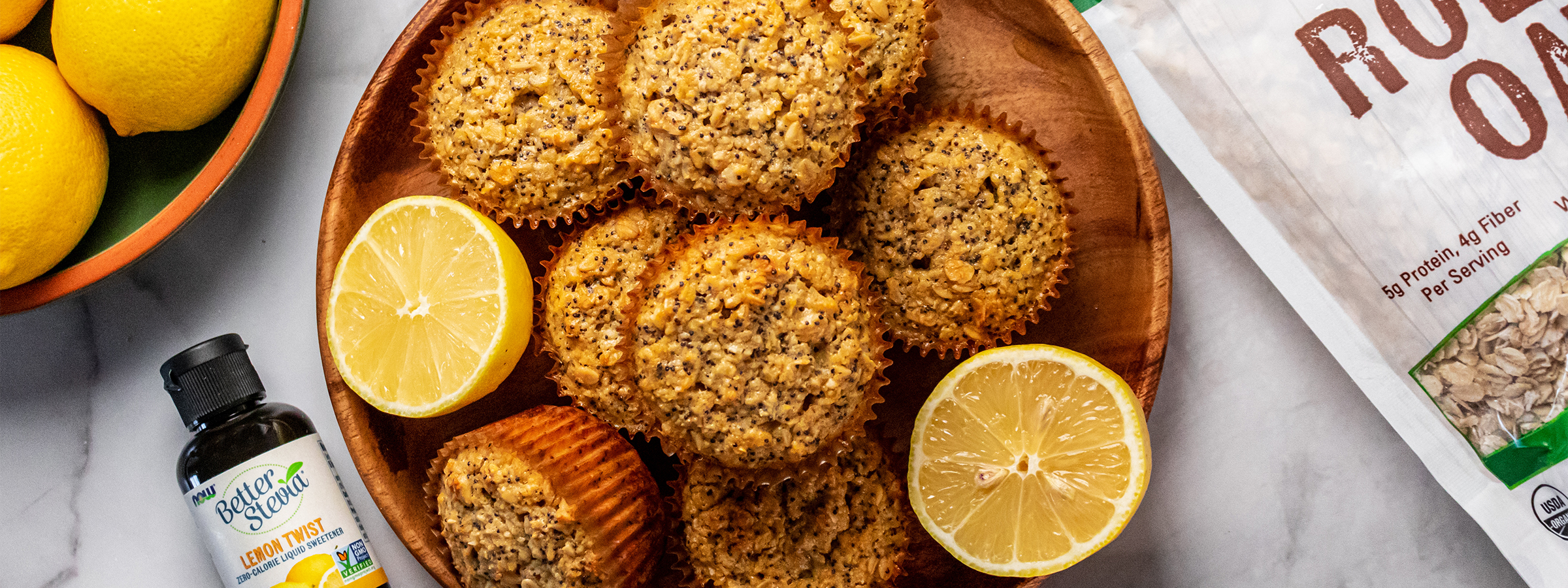top view of Lemon Poppyseed Oat Muffins next to bottle of BetterStevia Lemon Twist and NOW Rolled Oats