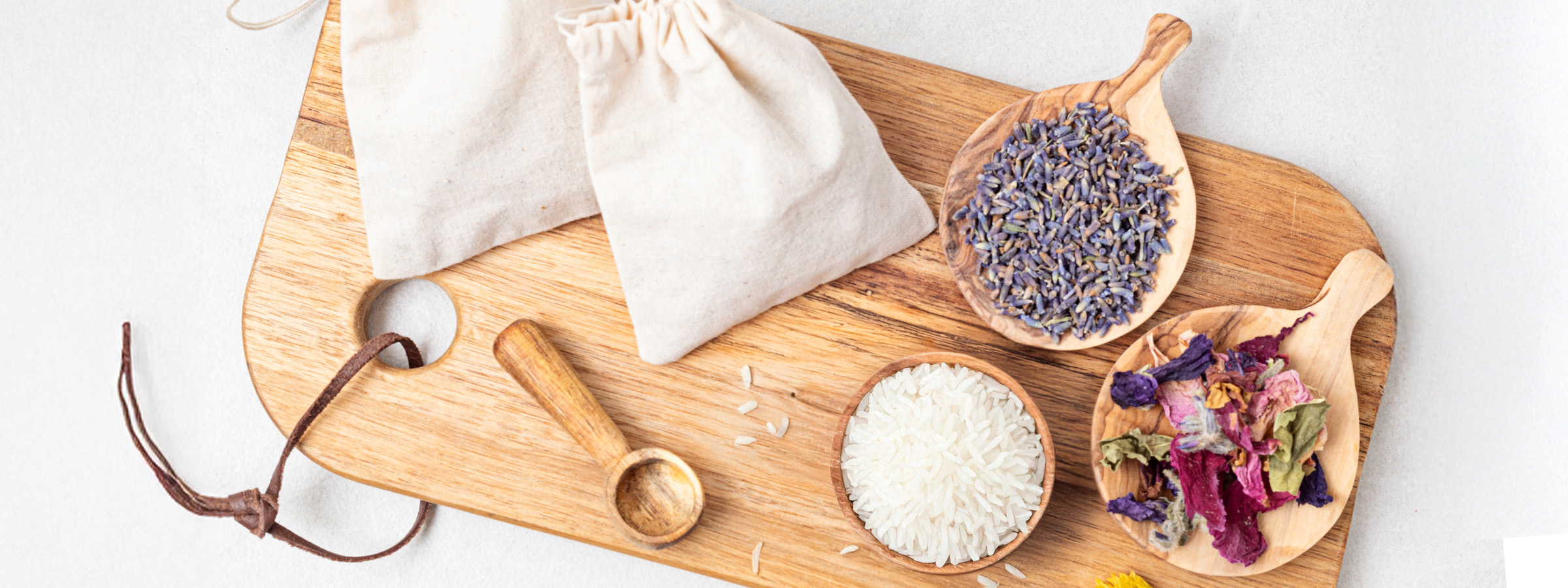 top view of Homemade Tea Tree and Lavender Essential Oil Sachets with lavender and rose petals on a wooden tray