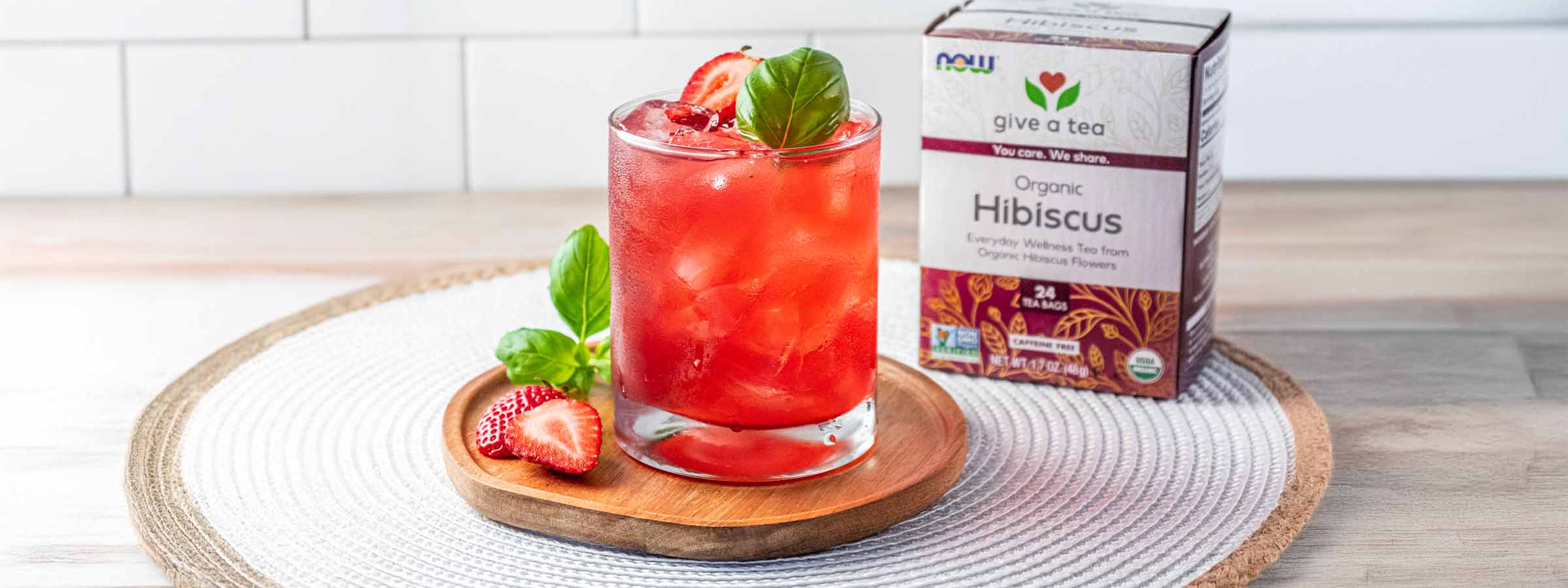 glass of Strawberry Hibiscus Aqua Fresca next to a box of NOW Hibiscus tea