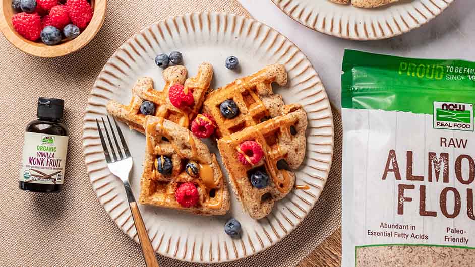 top view of Sugar-Free Vanilla Waffles in between a bottle of NOW Monk Fruit Vanilla and NOW Raw Almond Flour