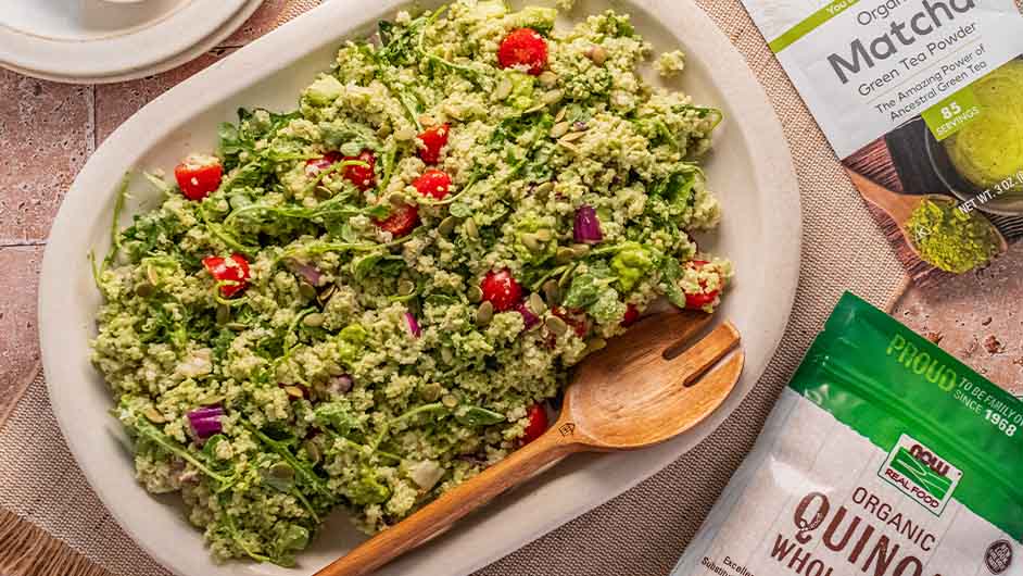 close up shot of Summer Quinoa Salad with Matcha Pesto with a wooden spoon in the dish