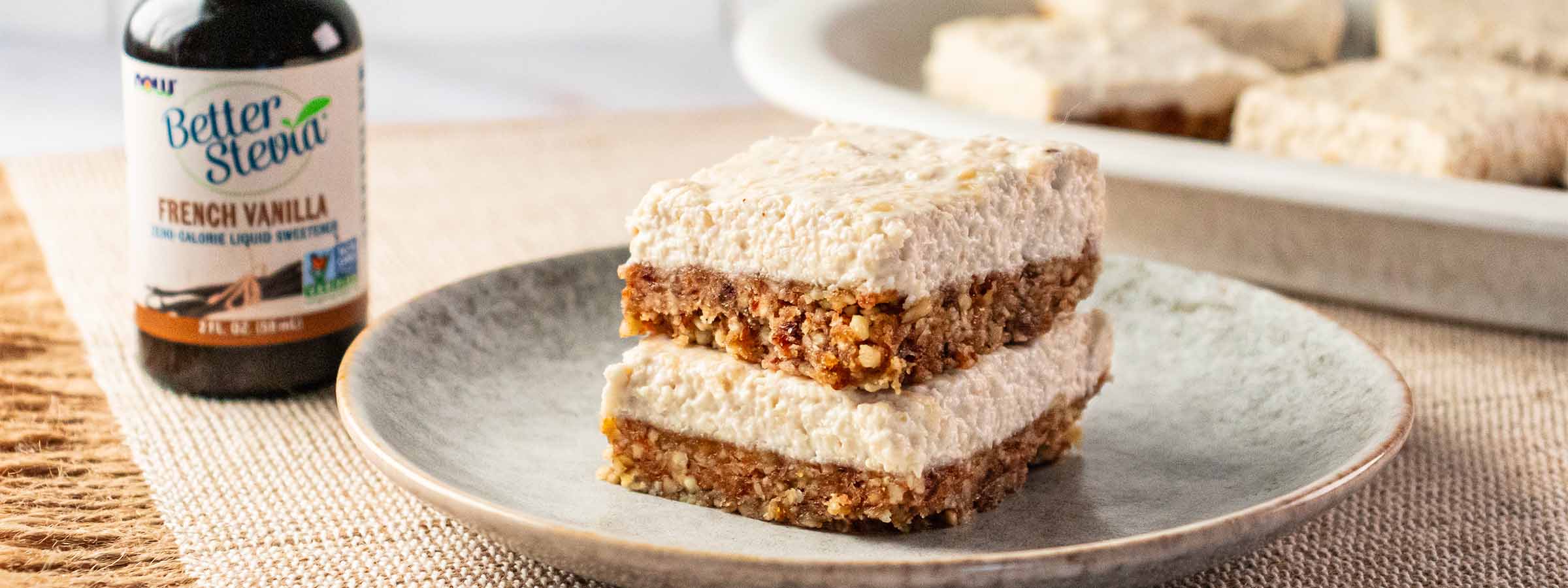 gray plate containing two Vegan No-Bake Cheesecake Bars stacked on top of each other next to NOW Monk Fruit Vanilla