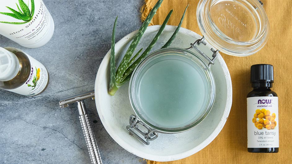 Glass Jar with Lid open with Light blue Shave Gel inside. bottle of NOW blue tansy essential oil, Bottle of Aloe Soothing Gel and bottle of Evening Primrose oil 