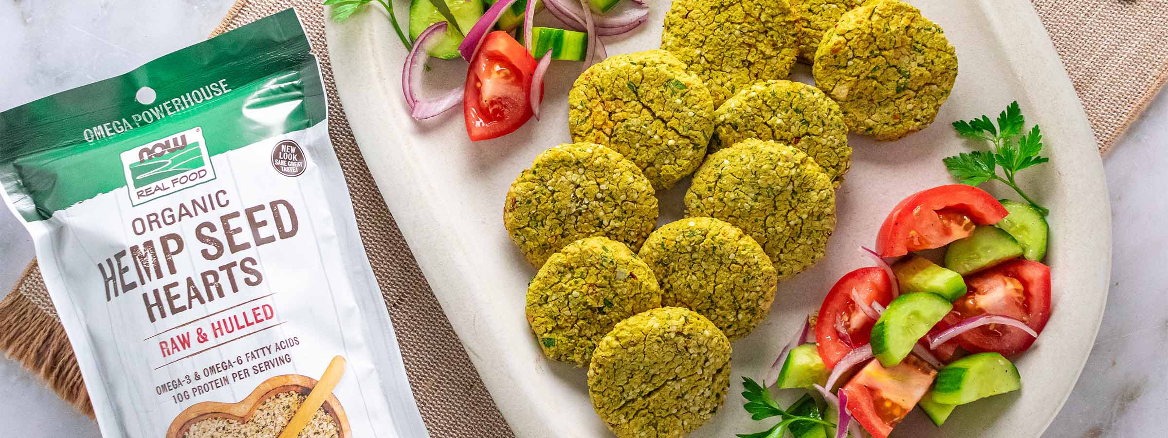 top view of High Protein Baked Falafel Patties next to a bag of NOW Hemp Heart Seeds