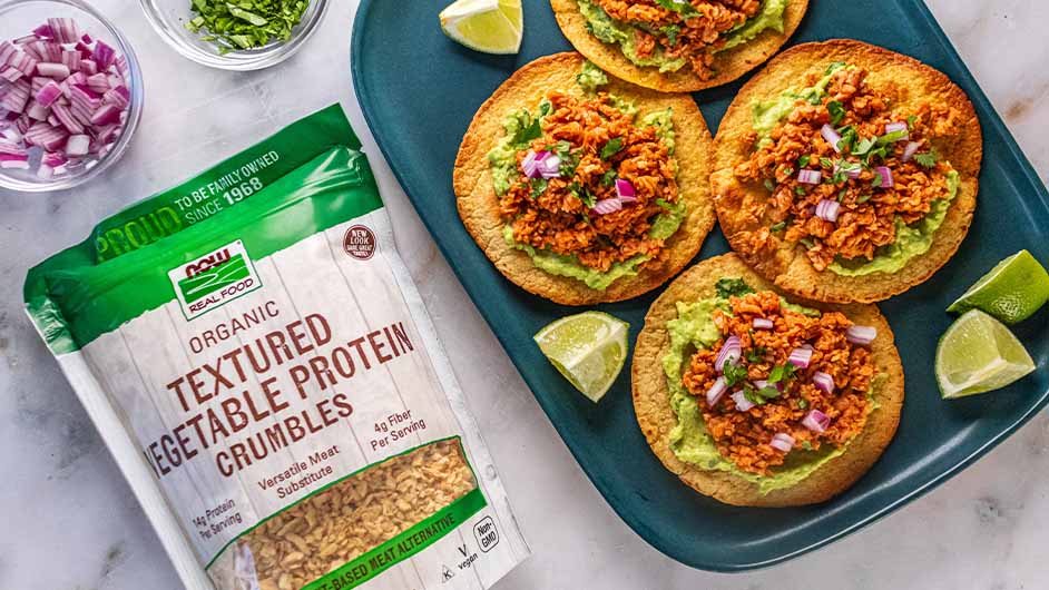 top view of Vegan Protein Tostadas next to a bag of NOW Textured vegetable crumbles