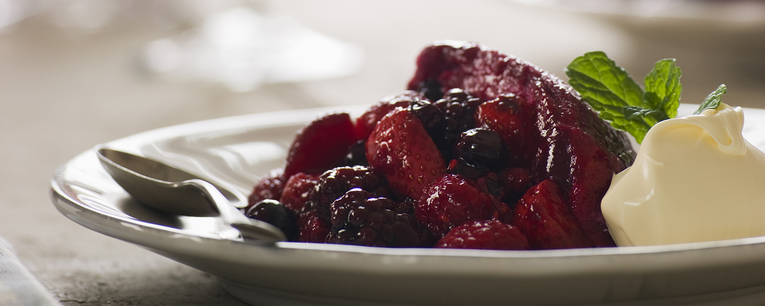 A white dinner plate is filled with Berry Compote, a dessert