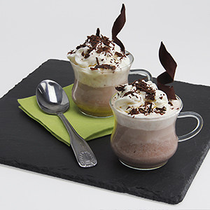 Two small glasses are placed on a black and green napkin and filled with light-brown Carob Hot Cocoa