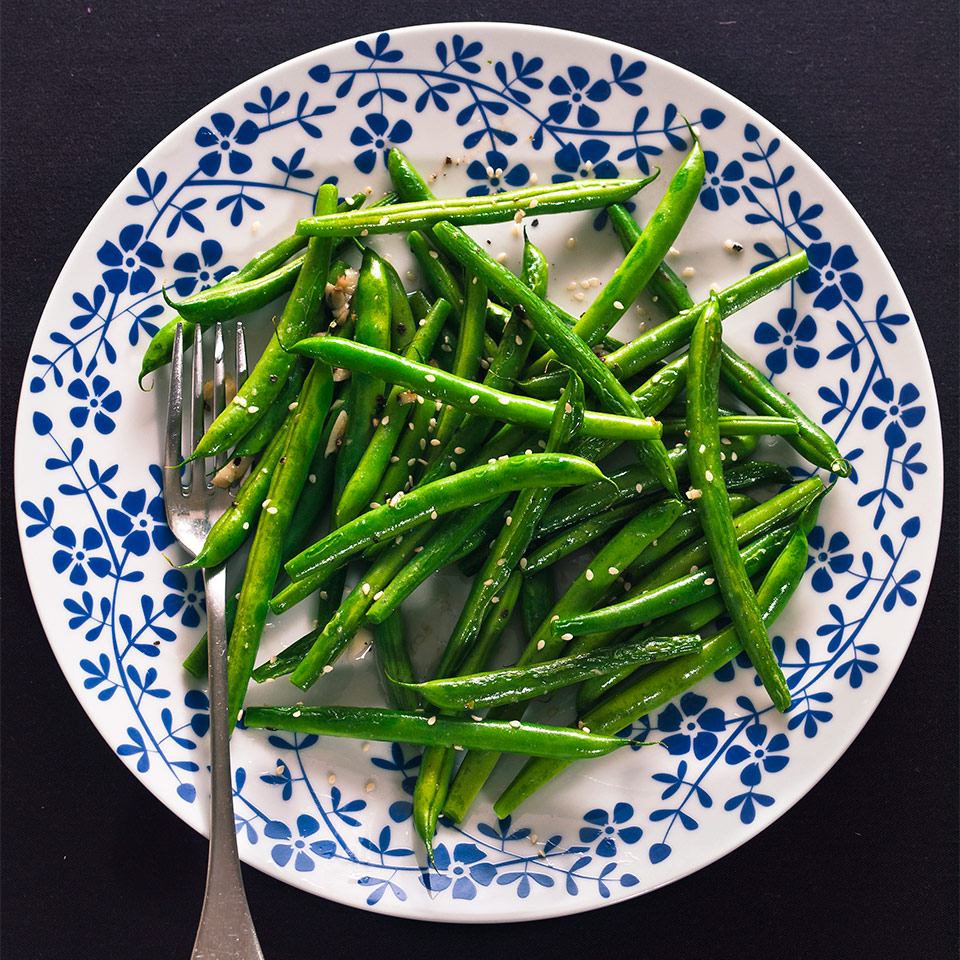 A white and blue plate is covered with Cashew Green Bean Stir Fry