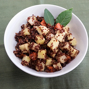 A white ceramic bowl filled with Glazed Red Quinoa with Root Vegetables