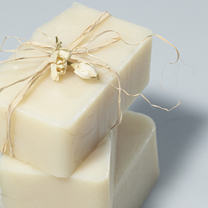 A closeup of a Luxurious Lotion Bar against a grey background