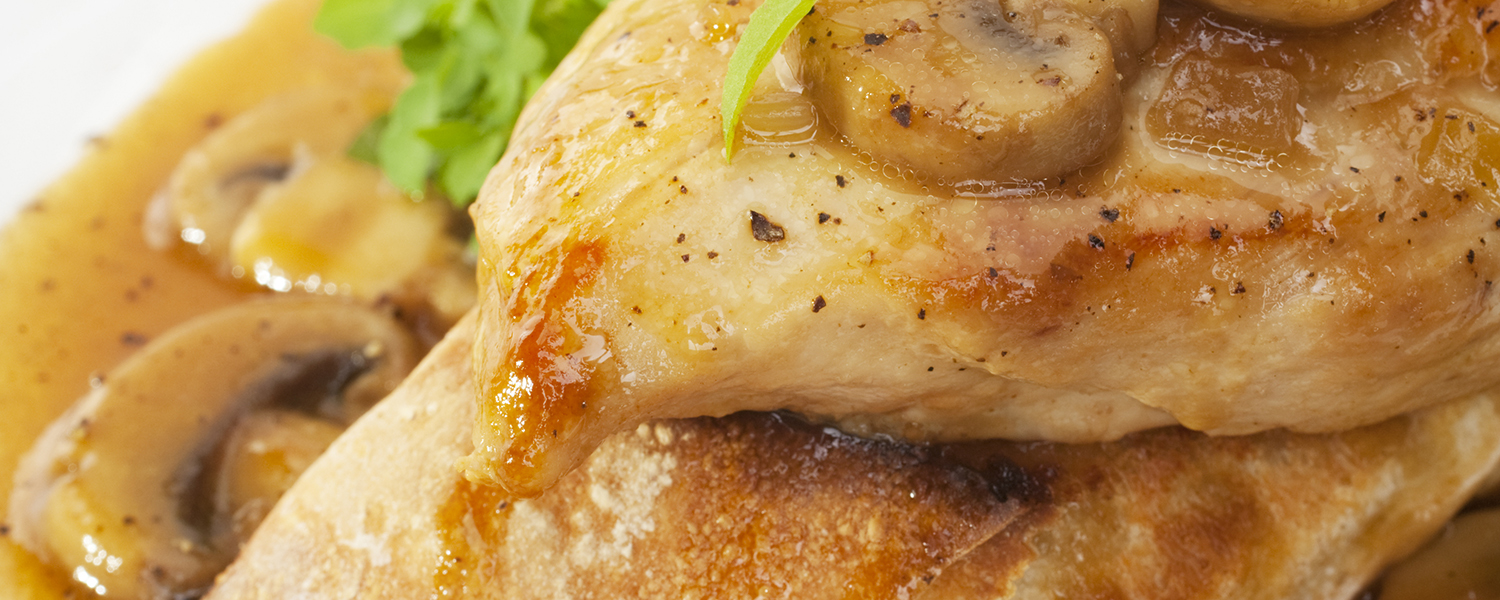 A closeup of the Mushroom Lemon Chicken dish. Ground black pepper is visible on the chicken.