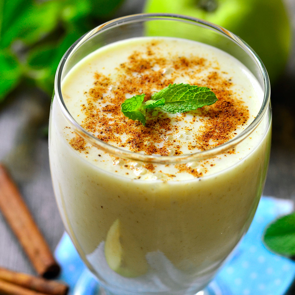 A tall, skinny drinking glass is filled with a serving of Spiced Ginger Chai Smoothie
