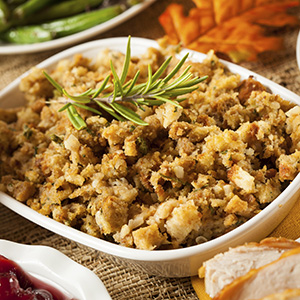 A white ceramic bowl on a brown placemat holds servings of The Ultimate Fiber Holiday Stuffing