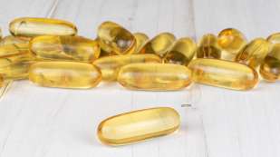 fish oil capsules on white wood