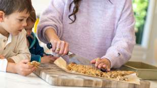 mom cutting homemade granola bars while children watch