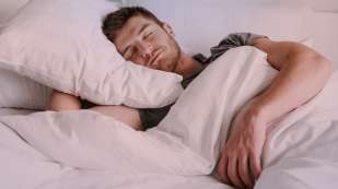light skinned male presenting person in bed asleep