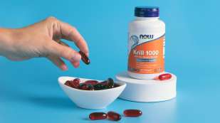 Krill Oil 500mg Softgels with a hand holding a softgel and a bowl filled with softgels