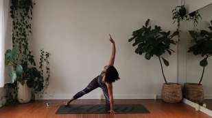 Georgette Dunn stretching on a dark yoga mat
