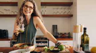 Healthy senior woman smiling while holding some green juice