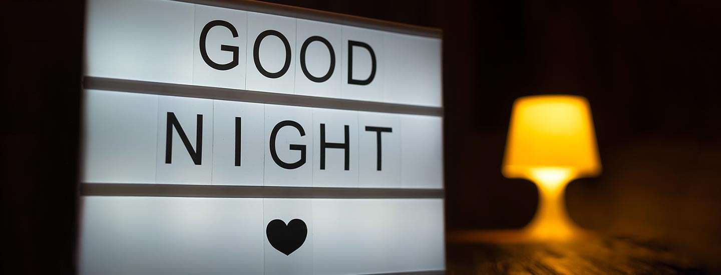 Good night sign with lamp in the background