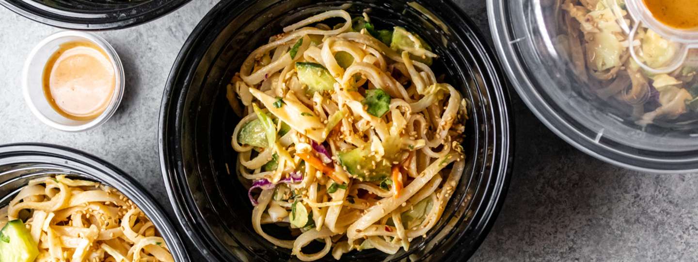top view image of nutty peanut noodles in black bowl 