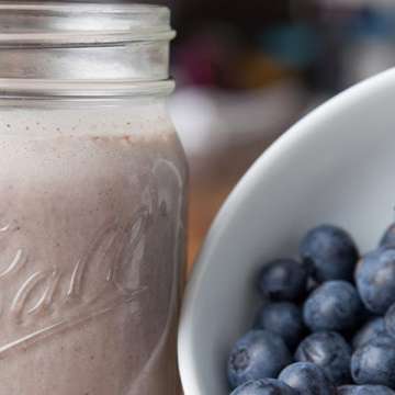 fruit smoothy in mason jar. Bowl of blueberries.