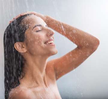 light skinned, female presenting person taking a steamy shower
