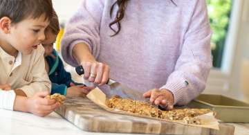 mom cutting homemade granola bars while children watch