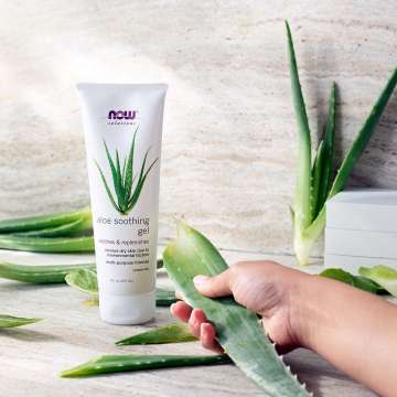 NOW Solutions Aloe Soothing Gel with a hand holding aloe leaf