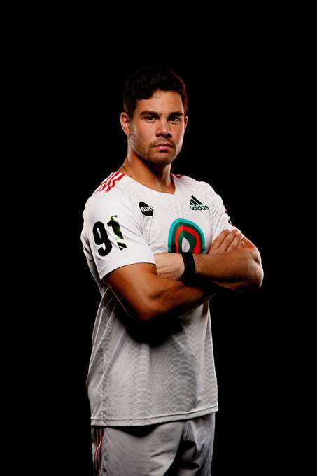 Joe Nordella in lacrosse uniform with arms folded looking intently at the camera