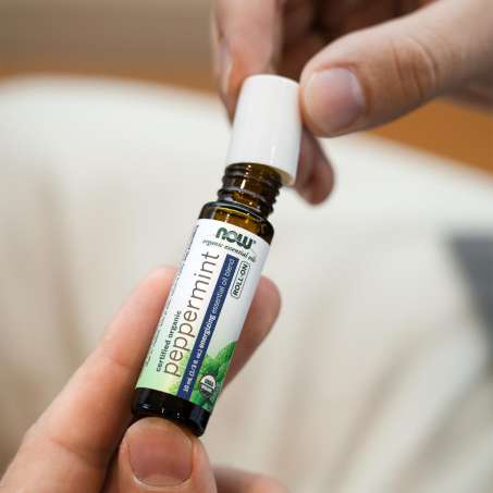 person closing the lid of NOW Peppermint E-Oil Roll on