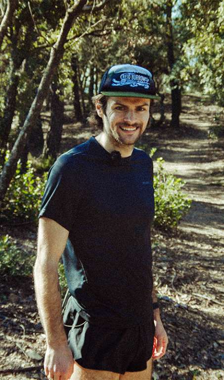 Reid Burrows standing on a trail looking at the camera