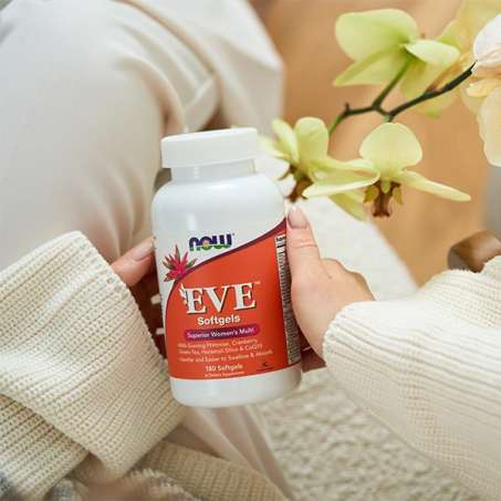 female light skinned hands holding bottle of NOW EVE Vitamins