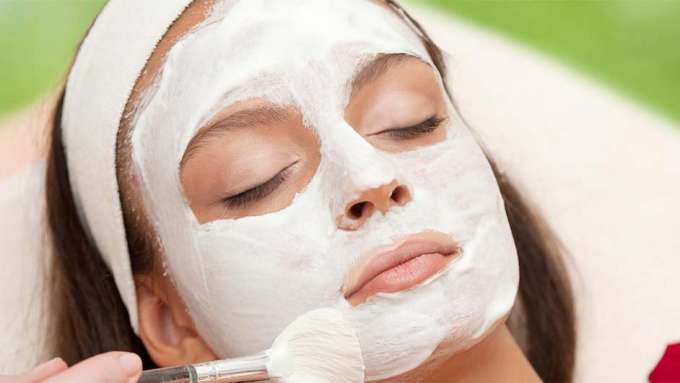 close up image of a female presenting person wearing a light green face mask with a lime green background