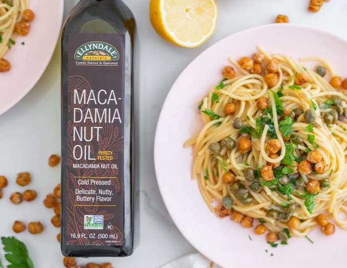 bowl of lemon caper pasta next to a bottle of ellyndale macadamia nut oil