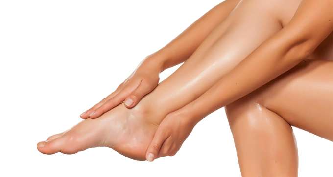 light skinned female presenting hands touching her foot. 