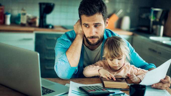 stressed adult with child on lap at table