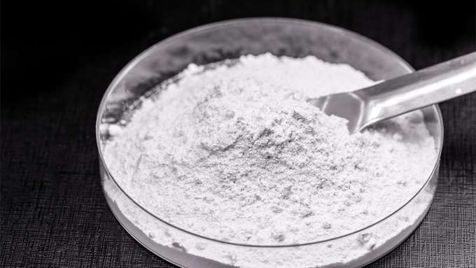 clear dish of white powder, silicon dioxide with small sliver spoon