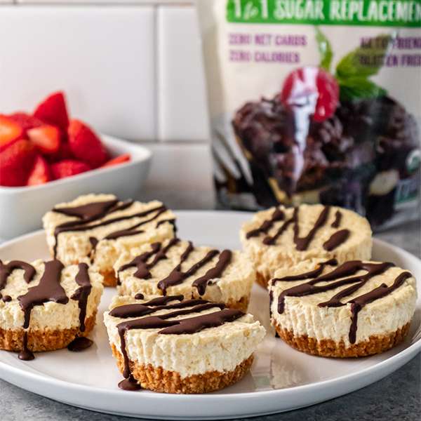 peanut butter cheese cups on white plate with blurry monk fruit in the back ground