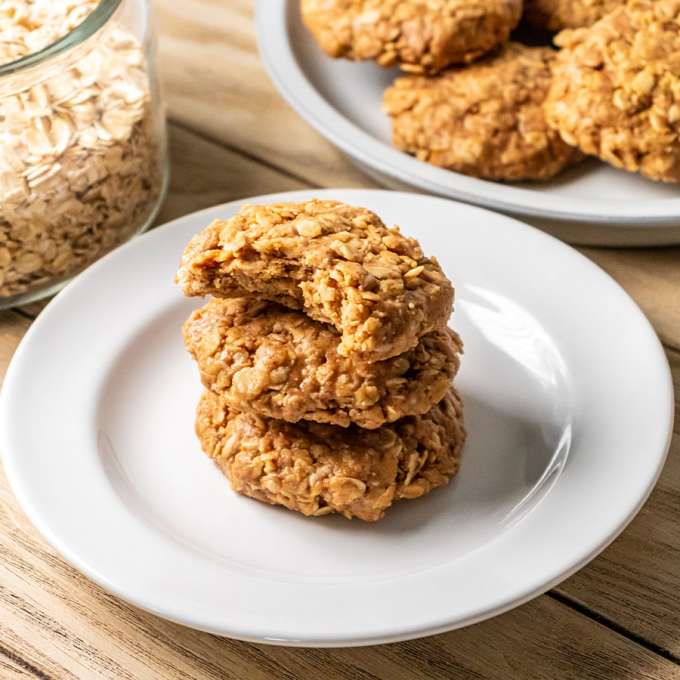three no bake peanut butter oatmeal cookies stacked on top of each other on a white plate
