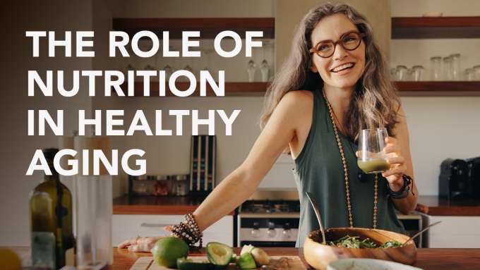 woman with glasses holding a glass with something green in it