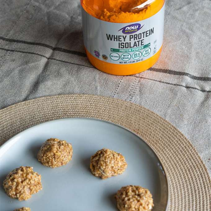 plate of Almond butter and Oatmeal protein bites with bottle of NOW Whey Protein Isolate in the background