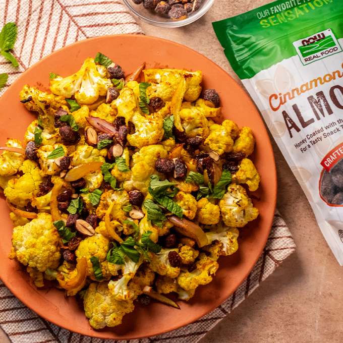 top view of Middle Eastern Roasted Cauliflower net to bag of NOW Cinnamon Almonds