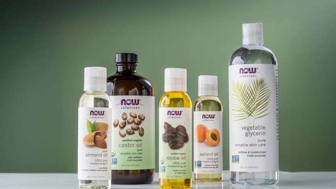 group shot of NOW Carrier oils with a green background 